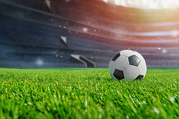 Obraz premium ball on the green field by sun light in soccer stadium. ready for game in the midfield - big poster with copy space.