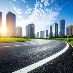 Fototapeta premium A curved road with white lines leads to a city skyline