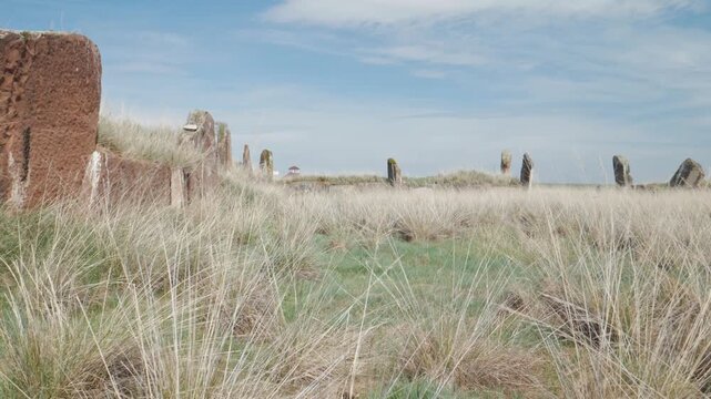 Handheld wide shot of the ancient megalithic complex at the Great Salbyk Kurgan in Khakassia. Massive standing stones span the grassy steppe in the historic Valley of the Kings.