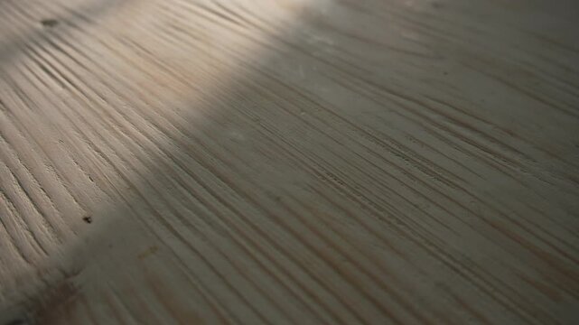 Sunlight moving across wooden surface with linear grain texture