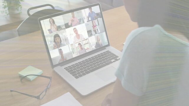 Woman joining scheduled business meeting, watching laptop 3x3 grid while referencing sticky notes