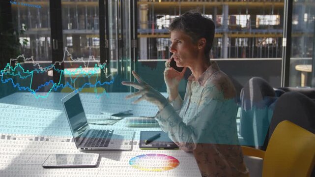 Designer typing while on phone, tap sparking graphs over laptop tablet color wheel reviewing design