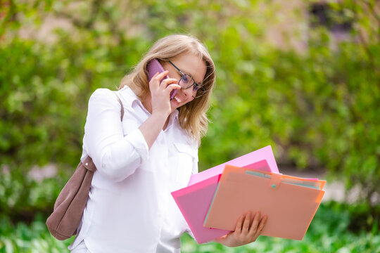 Diligent woman professor with phone and documents. Business multitasking and academic administration.