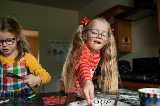Child sticking her tongue out while getting more chocolate spread while baking