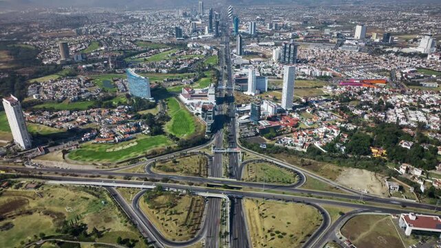 Aerial steady shot of Angel&oacute;polis in Puebla, Mexico, showing modern buildings, urban growth and major roads including V&iacute;a Atlixc&aacute;yotl and Municipio Libre boulevard.