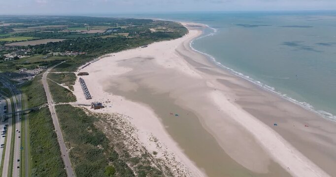 Aerial view of the Veerse Meer and beach contrasting the blue water, sandy shore and green land, creating a tranquil coastal scene, Veersedam, Netherlands.