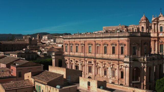 The magnificent Baroque Duomo of Noto Sicily rising above sweeping city rooftop views
