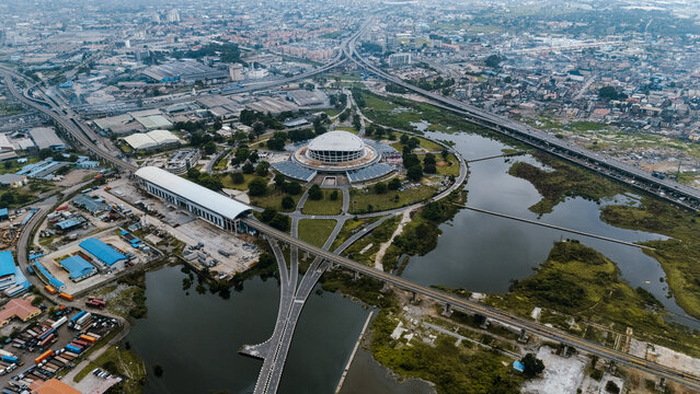 Aerial view of the National Theatre, a cultural landmark, stands amidst the urban sprawl, its circular form contrasting with the linear roads, Lagos, Lagos, Nigeria.