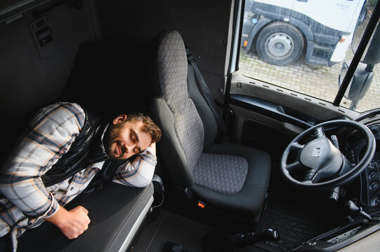 Truck driver sleeping in cabin during transport break