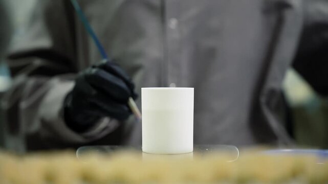 Person lighting a cannabis joint inside a professional cannabis lab production setting