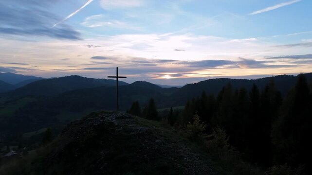 Silhouette of a religious cross on rocks during golden hour