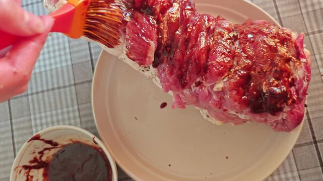 Grilling meat with marinade preparation in a kitchen setting