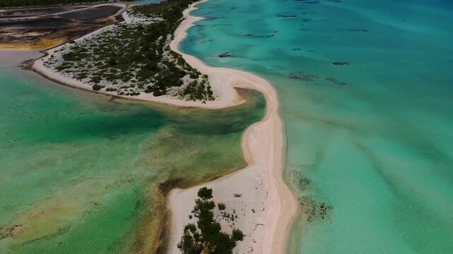 Aerial view of a stunning sandbar cutting through shallow turquoise waters, juxtaposed against the darker hues of the lagoon, French Polynesia.