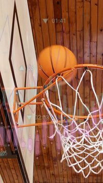 Vertical video: player releasing ball during training, ball passing rim, timers obscuring view