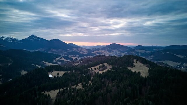 Aerial hyperlapse of mountain ridges and valleys at sunset in March