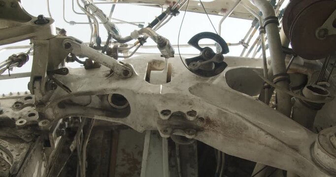 Close up view of intricate hydraulic lines and mechanical parts inside an aircraft structure