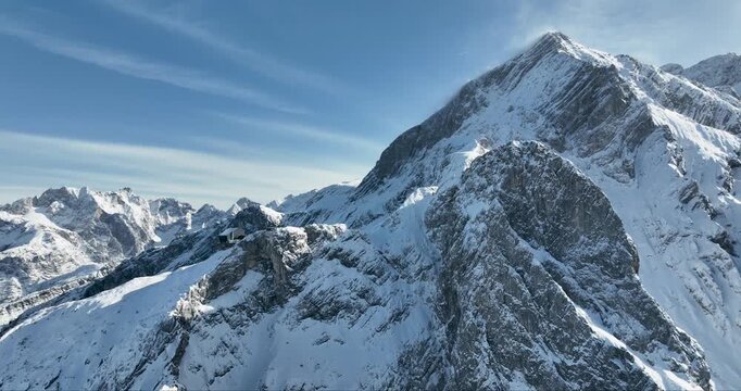 Aerial view of snow-capped mountain peaks under a clear sky, a landscape of contrasting textures and tones, Garmisch-Partenkirchen, Bavaria, Germany.