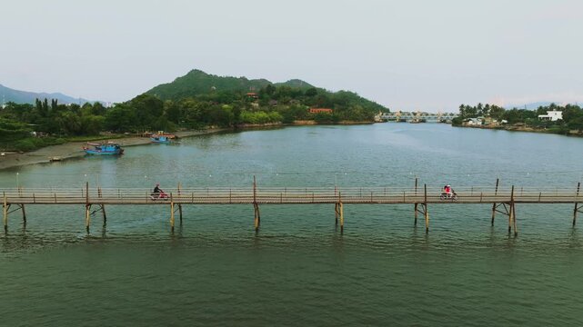 Aerial 4K of traditional Phu Kien wooden bridge crossing Cai River, Nha Trang, Vietnam
the authentic charm of rural Vietnam, highlighting the traditional engineering, peaceful tropical landscape