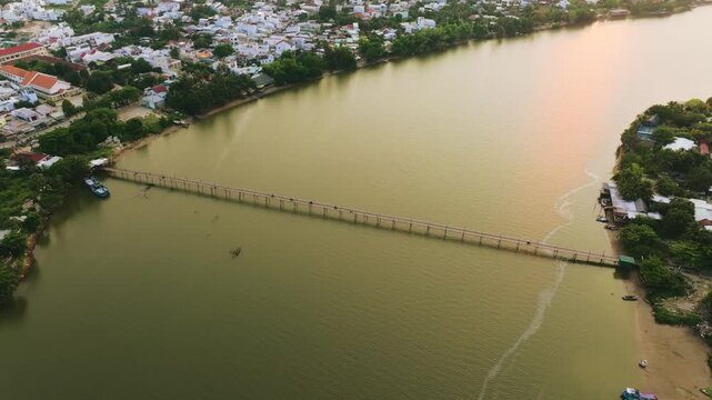 Aerial 4K of traditional Phu Kien wooden bridge crossing Cai River, Nha Trang, Vietnam
the authentic charm of rural Vietnam, highlighting the traditional engineering, peaceful tropical landscape