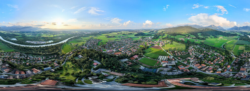Aerial view of the Inn River snaking past the charming town nestled amidst the rolling green hills, Neubeuern, Bavaria, Germany.