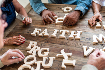 Hands arranging wooden letters creatively.