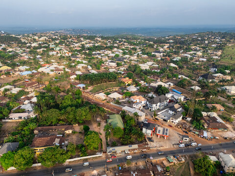 Aerial view of houses nestled among lush greenery and a visible road, creating a harmonious blend of urban and natural elements, Elu, Abia, Nigeria.