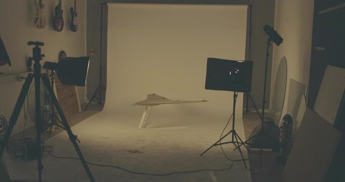Photography studio setup with a white backdrop and a small aircraft model on a stand