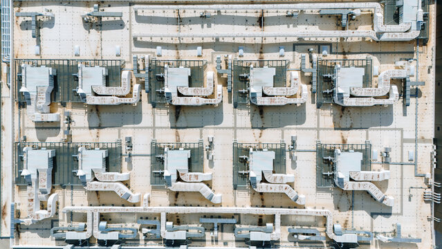 Aerial view of a complex rooftop HVAC system with intricate ductwork creating a geometric pattern against the weathered surface, Becej, Vojvodina, Serbia.