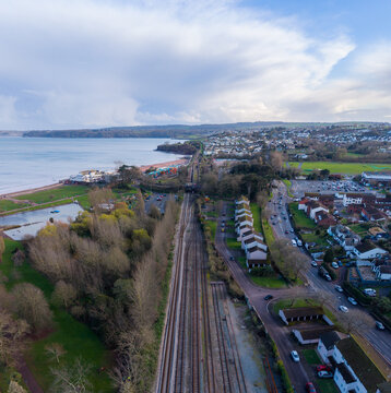 Aerial view of long train tracks cutting through the landscape near the coast, Paignton, England, United Kingdom.