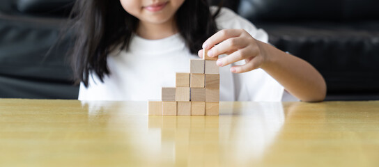 Wooden blocks rising steps child behind patience effort planning strategy step progress focus...