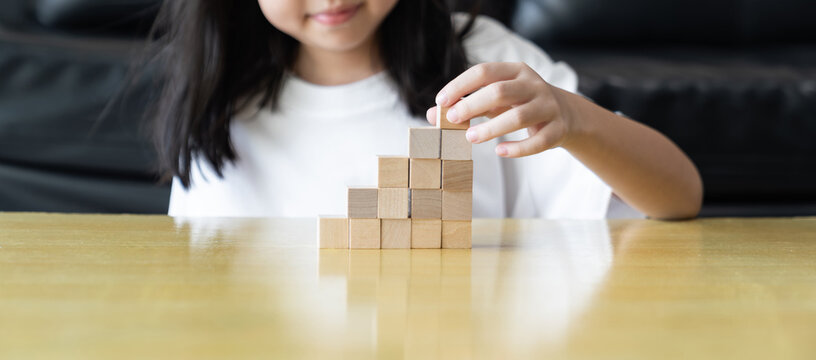 Wooden blocks rising steps child behind patience effort planning strategy step progress focus control consistency logical development achievement.