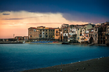 Obraz premium A magical summer holiday in Sicily. Cefalù, and its ancient town at sunset.
