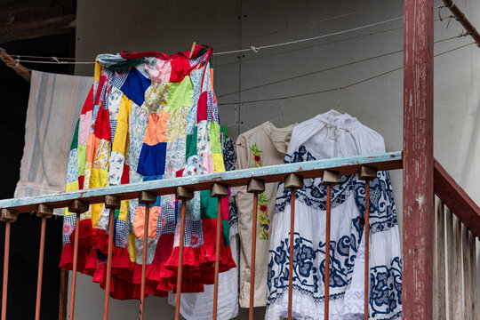 Traditional Panamanian pollera and a vibrant patchwork skirt hanging on a clothesline from a balcony in Casco viejo, Panama city, showcasing local culture and everyday life - stock photo