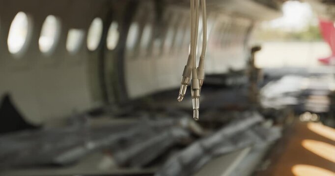 Close-up of disconnected electrical plugs hanging inside an empty aircraft fuselage