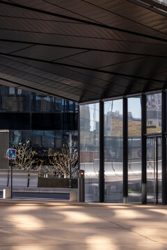Arcade with shadows on pavement and glass defines modern space in urban finance architecture La Defense with deep perspective in Paris France