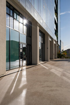 Walkway with shadows along a facade of windows shows modern lines in urban finance La Defense with minimalism and calm space in Paris France