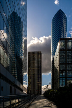 Skyscraper architecture corridor with glass reflections along a pathway in urban finance quarter La Defense with deep perspective in Paris France