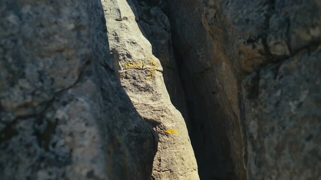 Close-up of limestone rock surface with light and shadow in a narrow crevice in El Torcal de Antequera, Spain, highlighting natural textures, erosion patterns and abstract geological forms.