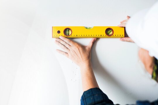 Repairman working with measuring ruller on the wall