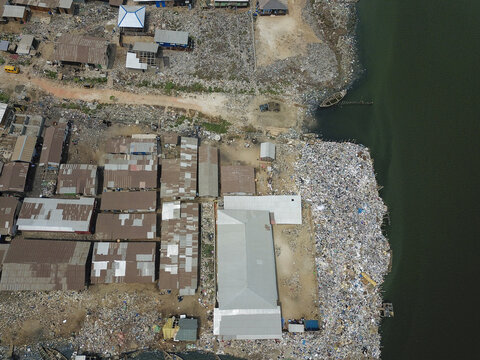 Aerial view of the landfill's stark contrast against the water, reflecting the harsh reality of waste management, Oworonshoki, Lagos, Nigeria.