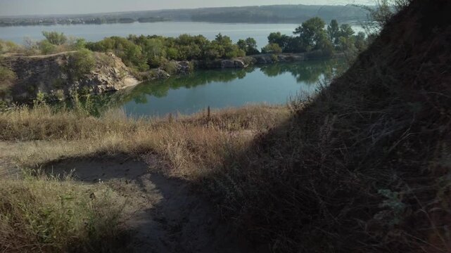 Serene nature scene. Tranquil route above clear waters with soft breeze and reflective calm. Ethereal journey along dry fork with sunlit grasses and serene reflective waters