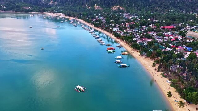 Vibrant boats dot the clear waters along the sandy coastline of Port Barton Beach, framed by lush greenery. Philippines