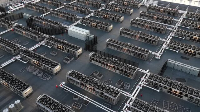 Large data center rooftop in Ashburn, Virginia, with rows of cooling units and rotating ventilation systems powering modern cloud computing and AI infrastructure in USA. Aerial top down flyover. 