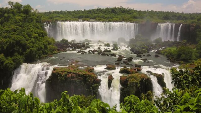 Close view of Salto San Martin waterfall over rocky cliffs with river and greenery, Iguazu Falls Argentina