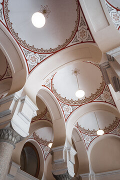 Sarajevo, Bosnia and Herzegovina - 07 May 2025: View of the Ashkenazi Synagogue's interior, where ornate arches meet intricate ceiling designs, bathed in the soft glow of hanging lights.