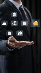 A professional businessman holds his hand out with floating digital icons symbolizing document management, data processing, file storage, and business information systems © Leo Lintang