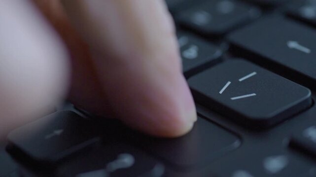 Closeup caucasian finger pressing enter, product QA testing scenario on black keyboard, repetitive taps, studio lighting, precise tactile feedback, focused inspection