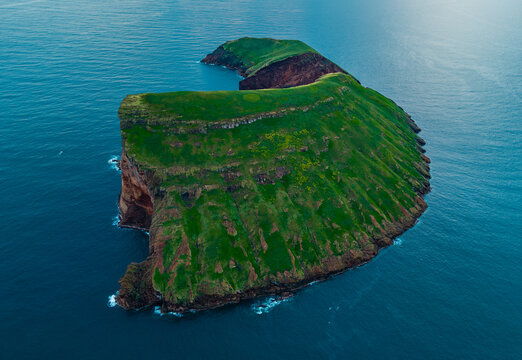 Aerial view of the verdant islet of Ilheus das Cabras rises dramatically from the turquoise waters, a vibrant contrast of nature's artistry, Terceira, Azores, Portugal.