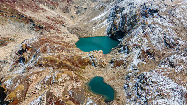 Aerial view of the serene, turquoise waters of a lake nestled amid rugged, snow-dusted mountains, Neelum Valley, Azad Kashmir, Pakistan.