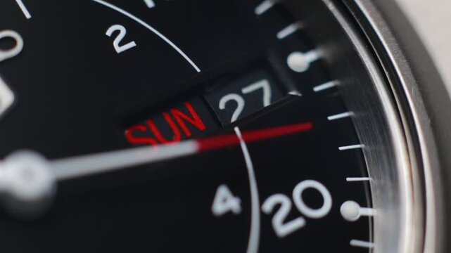 Macro close up of an automatic mechanical field watch with moving arms
